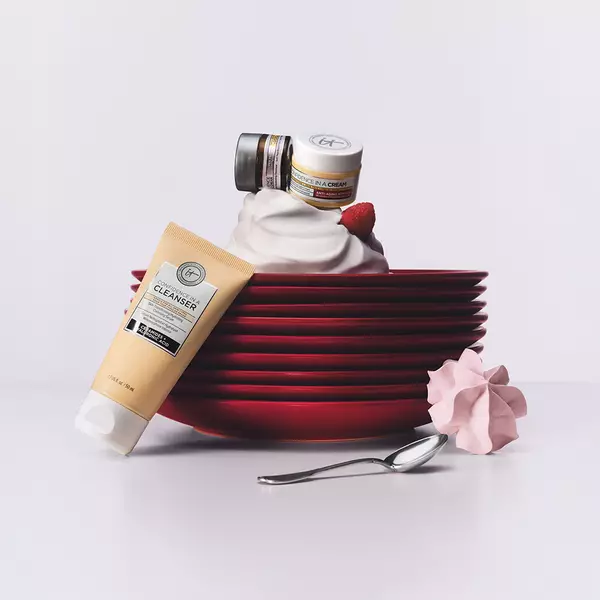 Various skincare products displayed on top of a stack of red plates