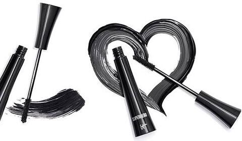 Two open tubes of IT Cosmetics Superhero mascara with black mascara swipes forming a heart shape.