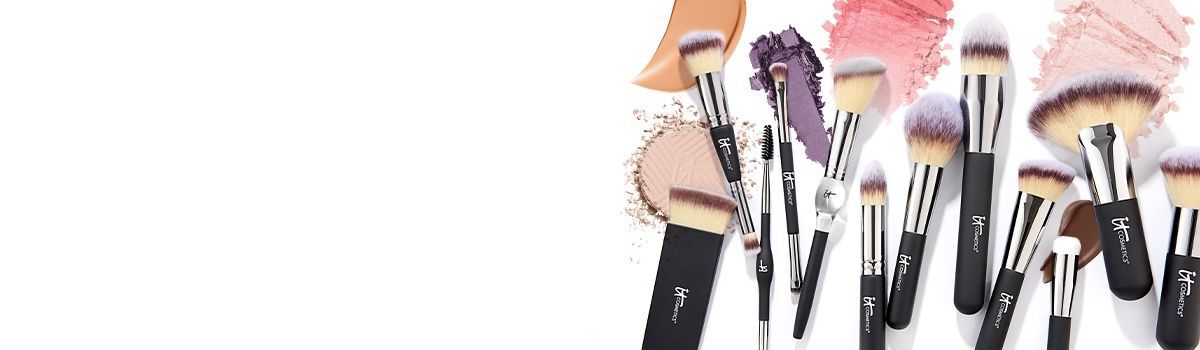 IT Cosmetics makeup brushes with powder, blush, and eyeshadow swatches in peach, purple, and pink shades.