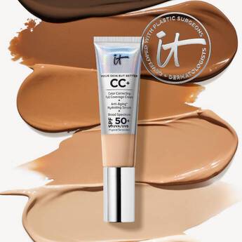 IT Cosmetics CC+ Cream tube with SPF 50+ placed over swatches of multiple foundation shades and brand logo in background.