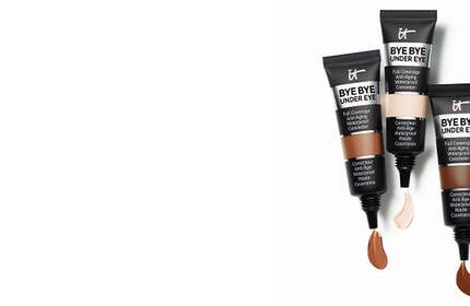 Three tubes of IT Cosmetics Bye Bye Under Eye Full Coverage Concealer in different shades with product swatches.